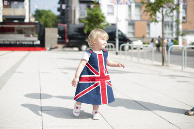 Girl looking away on footpath in city