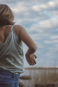 Midsection of woman standing against sky