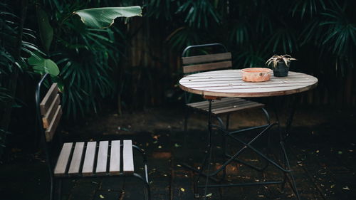 Empty chairs and table in yard