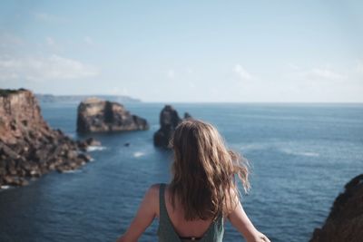 Rear view of woman looking at sea against sky