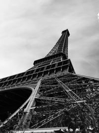 Low angle view of eiffel tower against cloudy sky