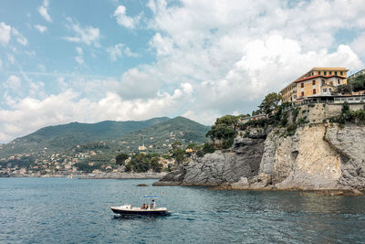 Scenic view of sea by buildings against sky