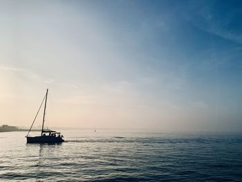Sailboat sailing on sea against sky