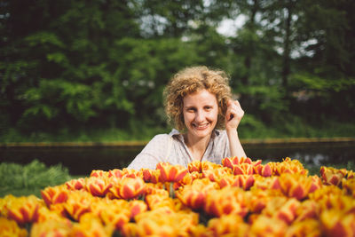 Portrait of smiling woman with orange flower