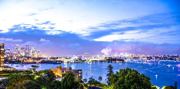 Panoramic view of sydney harbor against sky at night