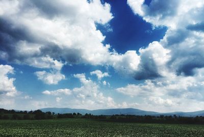 Scenic view of field against cloudy sky