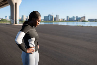 Exhausted ethnic runner taking pause in workout