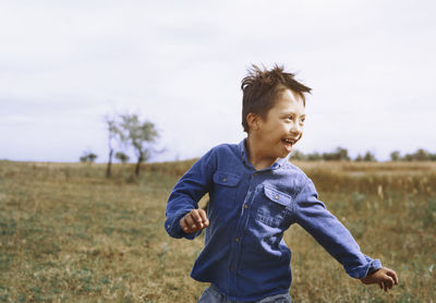 Boy with down syndrome running while looking back over shoulder