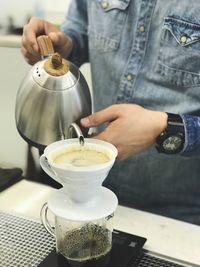 Midsection of man holding coffee cup