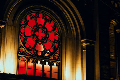 Low angle view of illuminated lamp in building at night