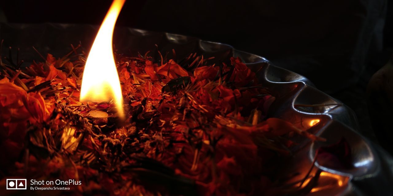 CLOSE-UP OF LIT CANDLE IN BURNING