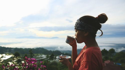Close-up of woman drinking coffee outdoors