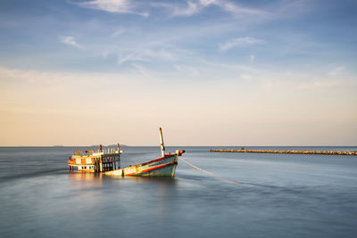 Boat sailing on sea against sky