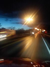 Light trails on road against sky at night