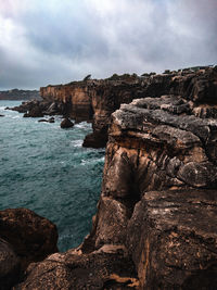 Rock formation on sea against sky