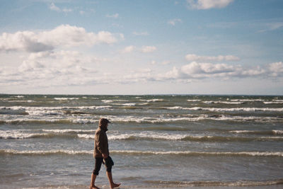 Man standing on beach against sky