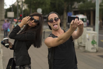 Man taking selfie with friend while standing on road