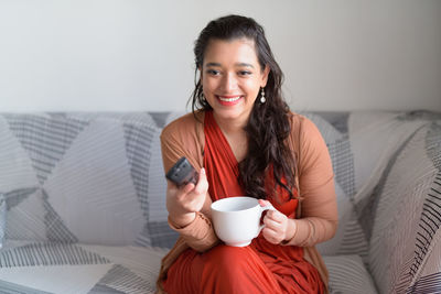 Portrait of young woman drinking coffee cup