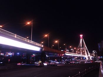 Illuminated bridge against sky at night