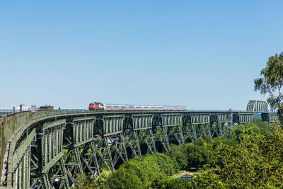 Train on bridge against clear sky