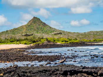 Scenic view of mountain by sea against sky