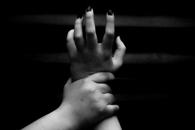 Man holding hand of woman against black background