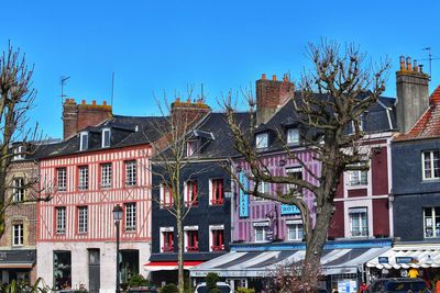 Buildings in city against clear blue sky