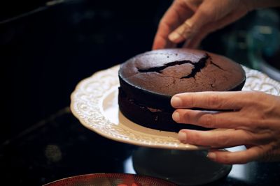 Cropped hand of man holding chocolate cake