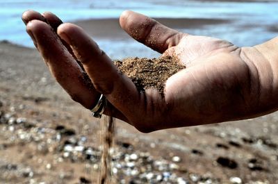 Sand running through fingers at beach