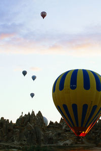 Hot air balloons flying against sky during sunset