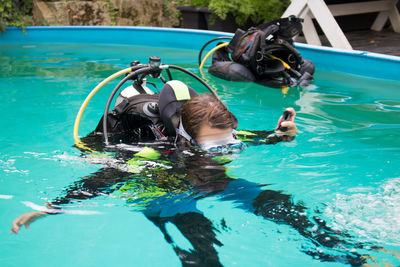 Woman with aqualung swimming in pool