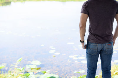 Low section of man standing in water