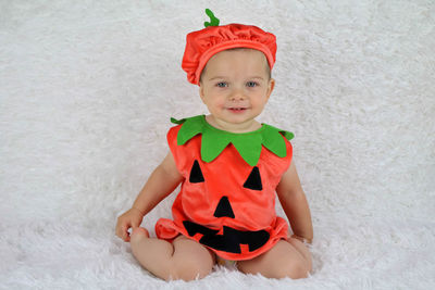 Portrait of cute baby girl sitting in hat