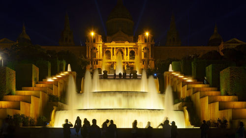 Group of people in fountain at night