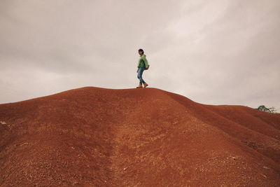 Full length of woman standing on mountain against sky