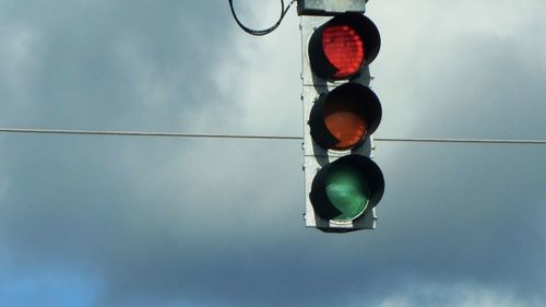 Low angle view of road signal against sky