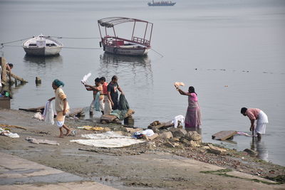 People on shore against sea