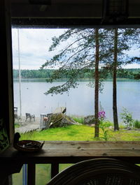 Chairs and table by window against sky