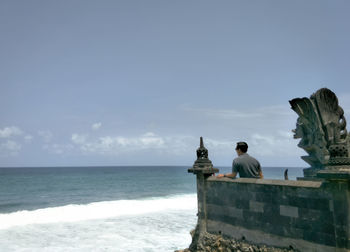 People looking at view of sea against sky