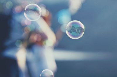 Close-up of bubbles in mid-air against sky