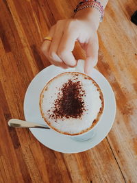 Directly above shot of cropped hand holding drink