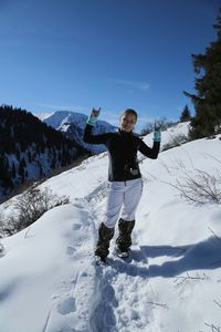 Portrait of woman gesturing while standing on snowcapped mountain