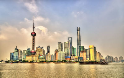 View of buildings in city against cloudy sky