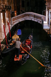 Rear view of man on boat in canal