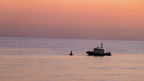 Sailboat sailing on sea against sky during sunset