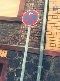 Road sign against brick wall