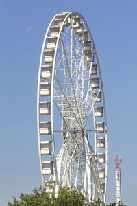 Low angle view of ferris wheel against clear blue sky