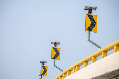 Low angle view of road sign against clear sky