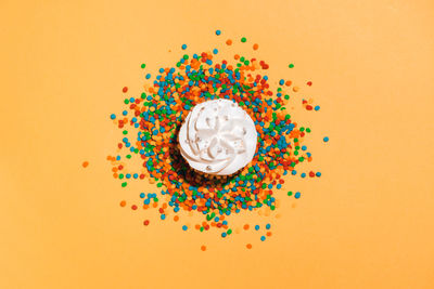 Directly above shot of multi colored candies against orange background