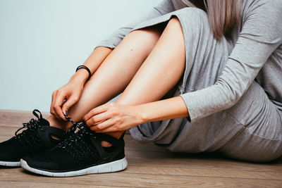 Side view of women tying up shoelace